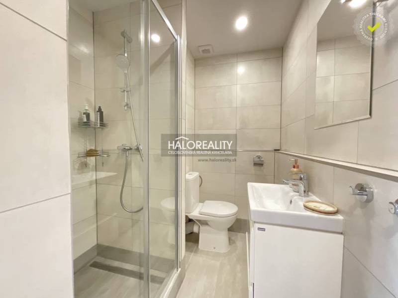 Koupelna v 1-pokojovém bytě s vanou, sprchovým koutem a umyvadlem.