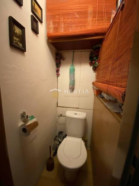 Malá toaleta v 2-pokojovém bytě s dekorativními bambusovými prvky a obrázky na stěně.