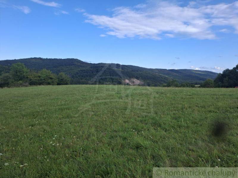 Krásné zelené pozemky k bydlení v Horním Tisovníku s panoramatem lesa a modré oblohy.