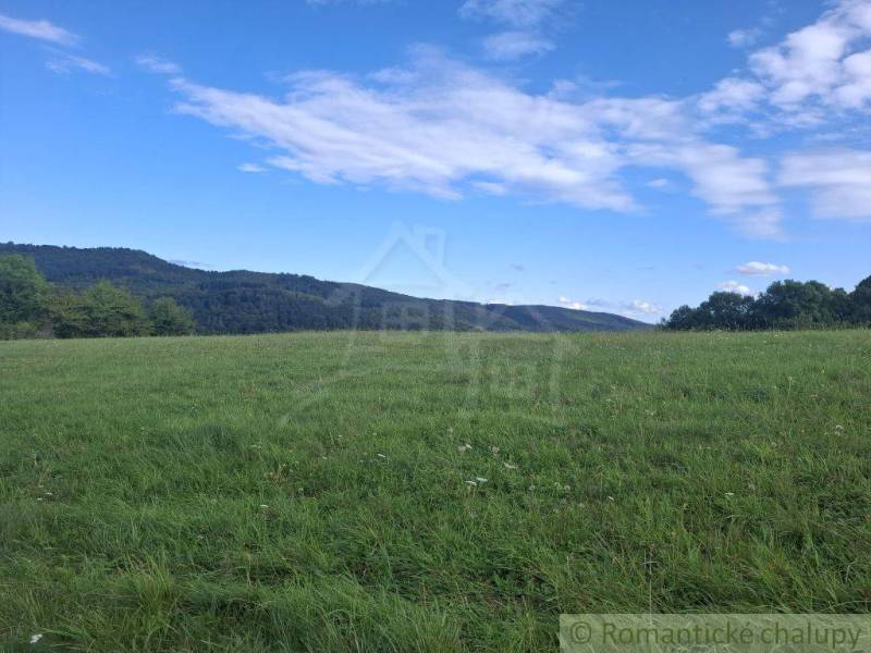 Zelená louka s kopci a oblohou v Horním Tisovníku, vhodná pro pozemky - bydlení.