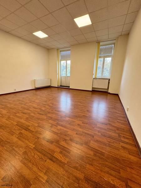 Kanceláře s podlahou s dřevěným dekorem, světlý interiér s velkými okny.