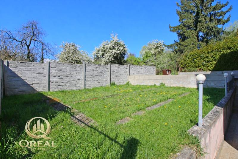 Zahrada u domu s trávníkem, moderním plotem a svítidly na Boskovičově ulici v Bratislavě.