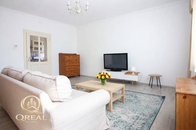 Obývací pokoj s televizí, pohovkou a konferenčním stolkem v 1-pokojovém bytě.