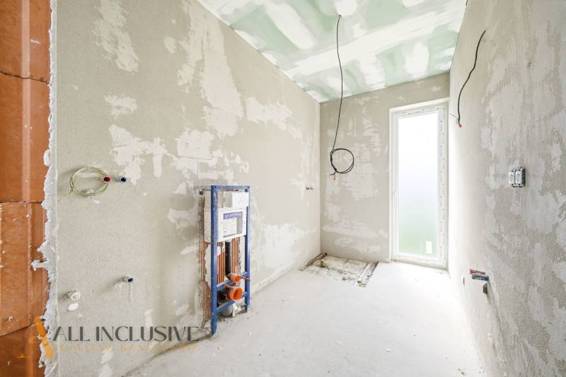 Interiér chaty s neomítnutými stěnami a přípravou na instalaci sanitárního zařízení.