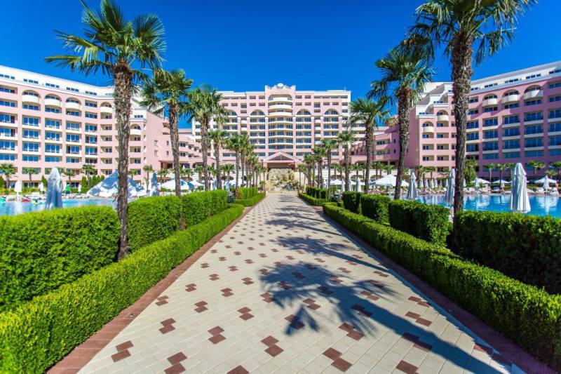 Růžový resort na Slunečném pobřeží s palmami a bazény na exteriérové fotografii.