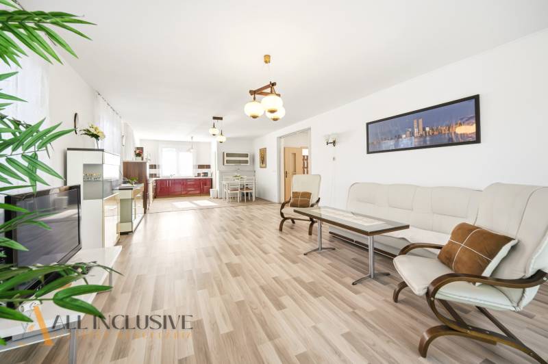 Obývací pokoj v rodinném domě s podlahou s dřevěným dekorem a světlým nábytkem.