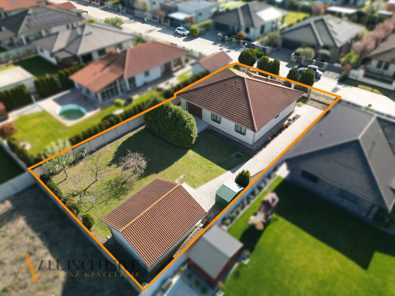 Rodinný dům v Kútnikoch se zahradou a parkováním, ohraničený plotem.