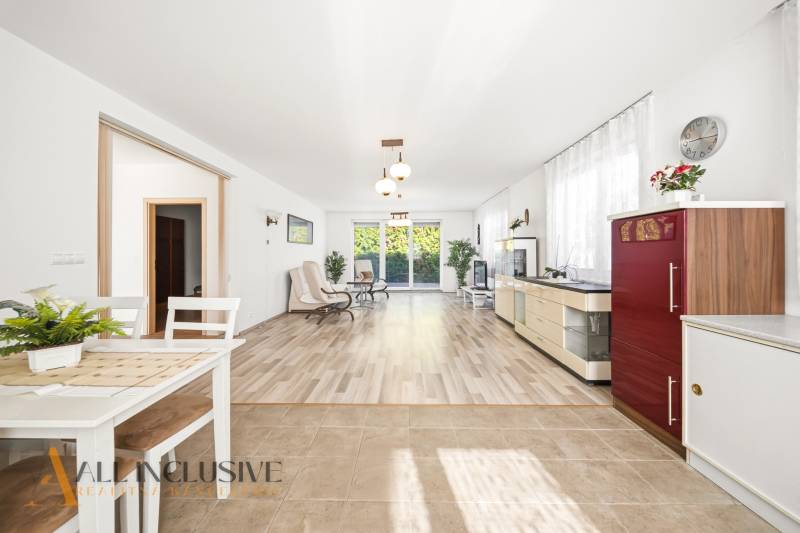 Interiér rodinného domu se světlým obývacím pokojem a podlahou s dřevěným dekorem.