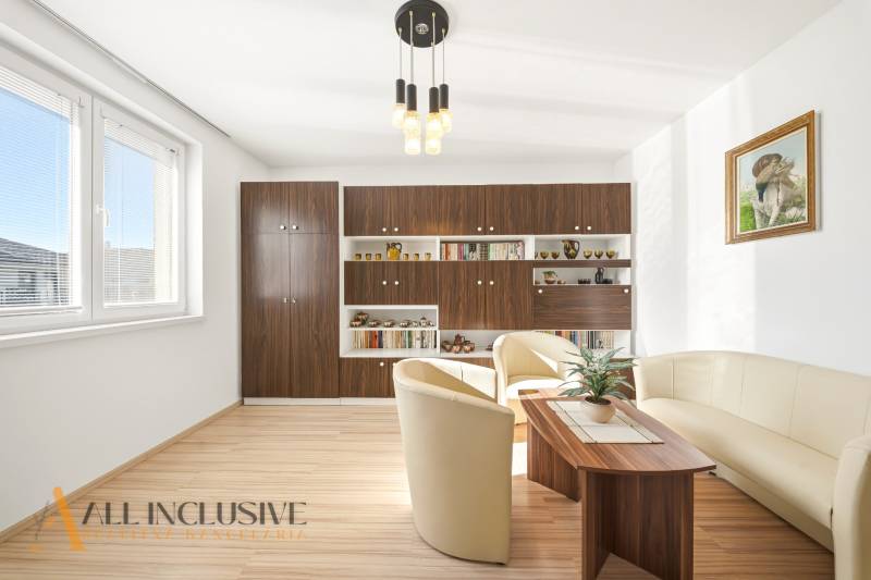 Obývací pokoj v rodinném domě s podlahou s dřevěným dekorem a pohodlným sezením.