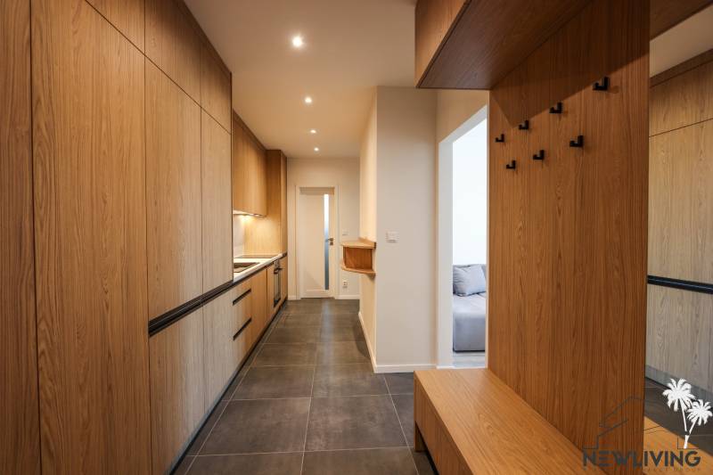 Vstupní hala 3pokojového bytu s úložnými skříňkami a závěsnými háčky.