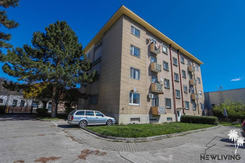 Bytový dům se zaparkovaným autem na Sasinkově ulici v Piešťanech.