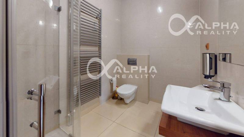 Koupelna v 2-pokojovém bytě s WC, sprchou a moderními sanitárními zařízeními.