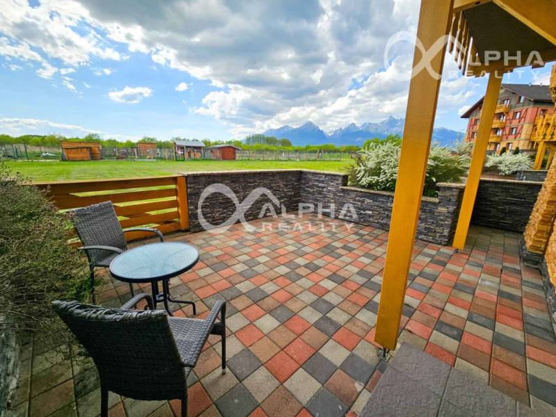 Terasa 2-pokojového bytu ve Velké Lomnici s výhledem na hory a zeleň.