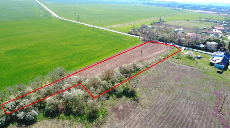 Pozemek v oblasti Zahrady Ondřejovce, obklopený polem a domy, ohraničený červenou čárou.