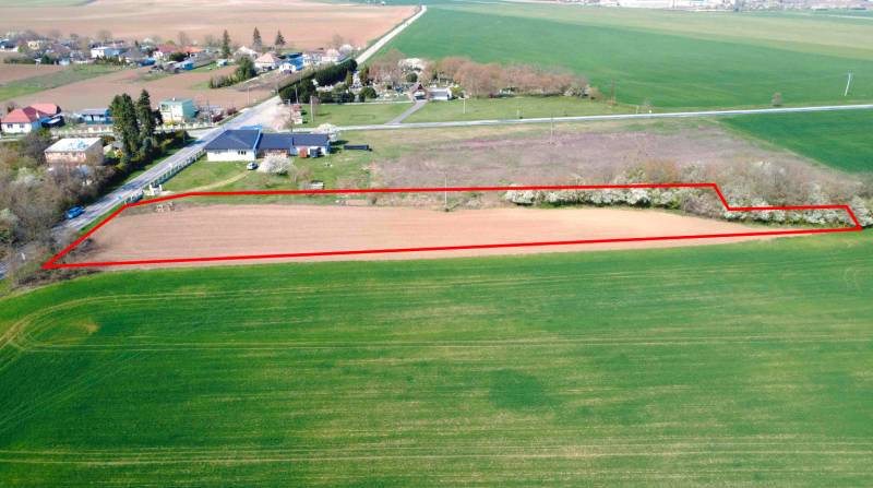 Pozemek v zahradách Ondřejovic, ohraničený červenou linií, obklopený otevřenou krajinou.
