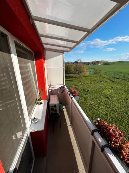 Balkon 3pokojového bytu v Gbelích s výhledem na zelené louky a květiny.