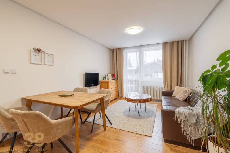 Obývací pokoj v rekreačním apartmánu s útulnou pohovkou a podlahou s dřevěným dekorem.