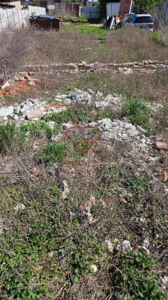 Pozemek na bydlení v Tešedíkově na ulici Tešedíkovo s neudržovanou vegetací a stavebním odpadem.