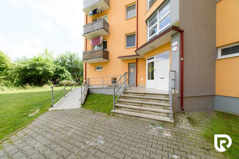 Bytový dům na Armádní ulici v Trenčíně s přístupovými schody a zelení.