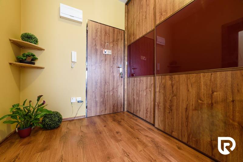 Interiér 2-pokojového bytu s podlahou s dřevěným dekorem a dřevěnými detaily.