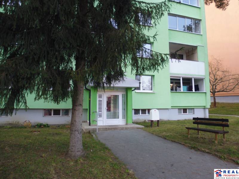 Vstup do bytového domu v Prešově, vhodný pro 2-pokojový byt, zelená fasáda.