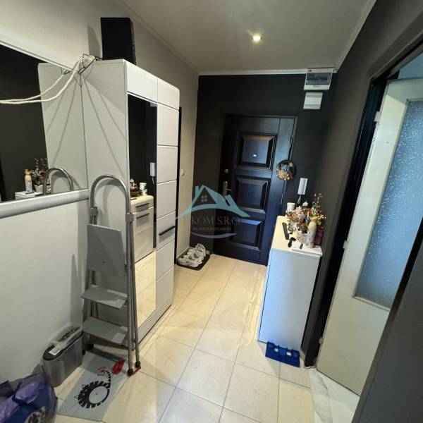 Vstupní hala se skříní a neutrálními barvami v 2-pokojovém bytě.