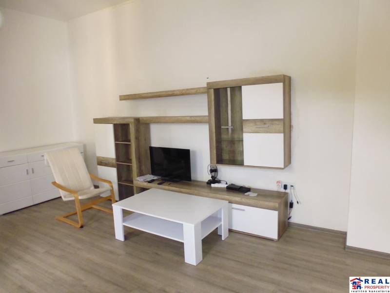 Obývací pokoj v 3-pokojovém bytě s TV stěnou a podlahou s dřevěným dekorem.