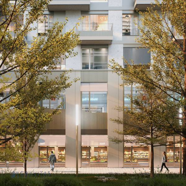 Exteriér na Mlynských nivách v Bratislavě-Ružinově s obchody a dřevinami před budovou.