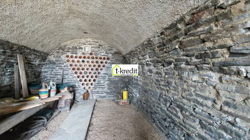 Kamenný sklep ve vinici s úložným prostorem na víno a policí na nádoby.