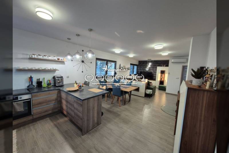 Kuchyně a obývací pokoj s podlahou s dřevěným dekorem v rodinném domě.