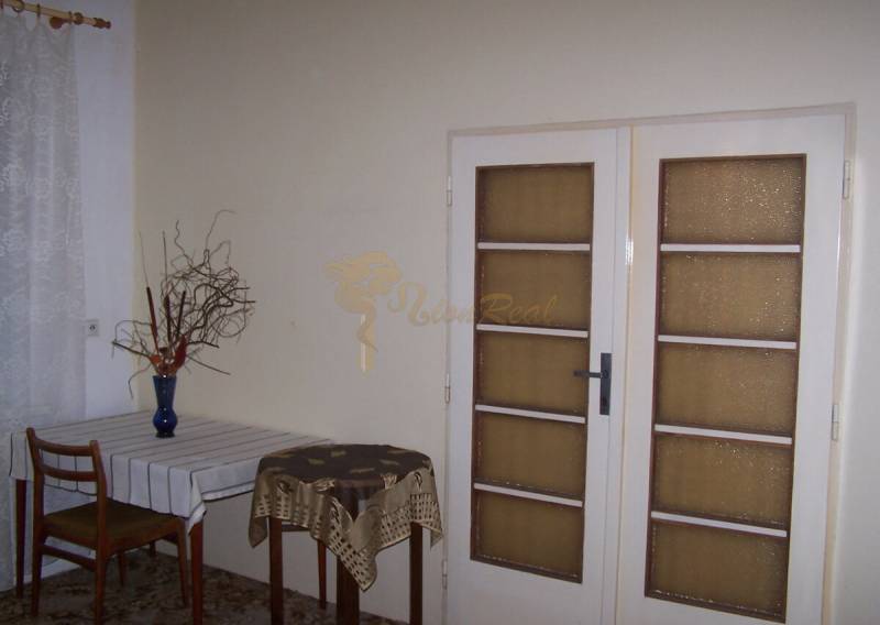 Interiér 2-pokojového bytu s jídelním stolem a prosklenými dveřmi.