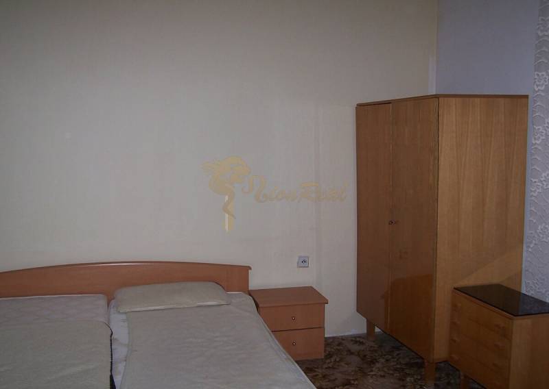 Ložnice v dvoupokojovém bytě s jednoduchým nábytkem a manželskou postelí.