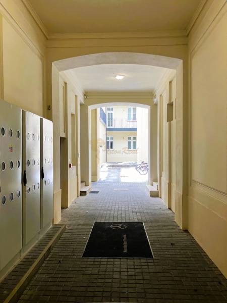 Chodba s kostkovanou dlažbou, kolo v pozadí, 2-pokojový byt na Konventní ulici.