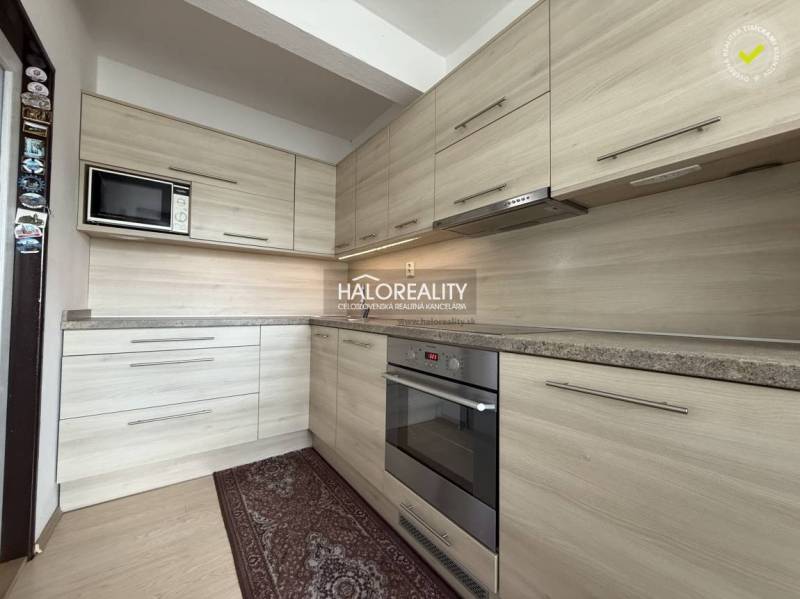 Kuchyně v rodinném domě s linkou a podlahou s dřevěným dekorem.