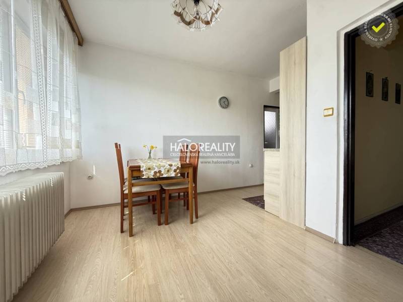 Jídelna s podlahou s dřevěným dekorem, stolem a židlemi v rodinném domě.