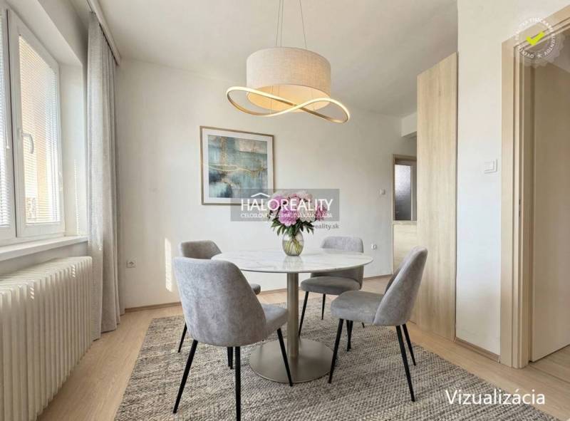 Jídelní kout v rodinném domě s kulatým stolem a elegantním svítidlem.