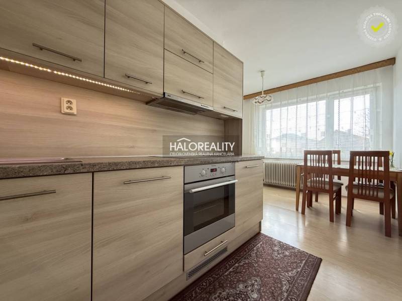 Kuchyně v rodinném domě s podlahou s dřevěným dekorem a jídelním stolem.