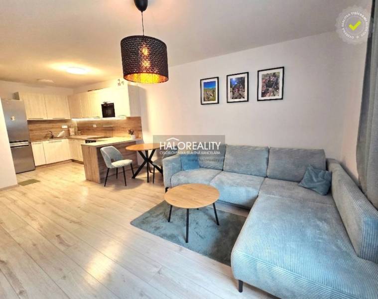 Obývací pokoj v 2pokojovém bytě s kuchyňským koutem a podlahou s dřevěným dekorem.