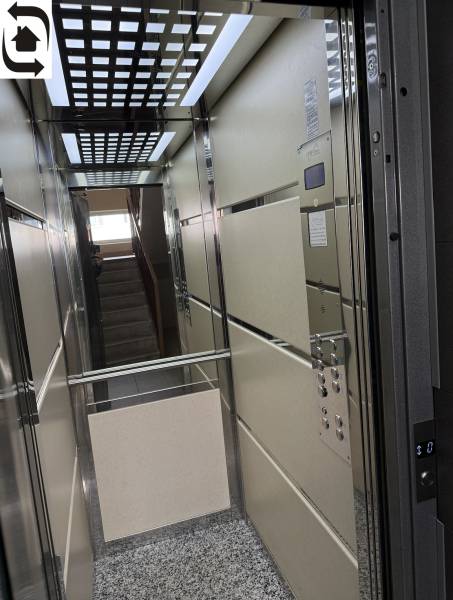 Výtah se zrcadlem a mřížkovaným stropem ve 4-pokojovém bytě.