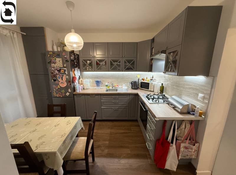 Kuchyně ve 4-pokojovém bytě s podlahou s dřevěným dekorem a rohovou kuchyňskou linkou.