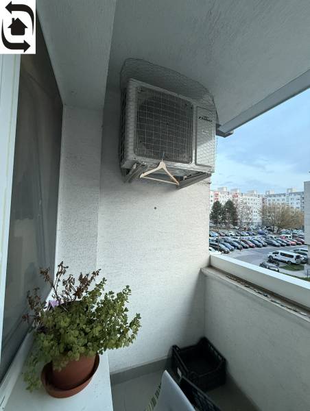Balkon 4-pokojového bytu na Kríkové ulici, Bratislava - Vrakuňa s květináčem a klimatizací.