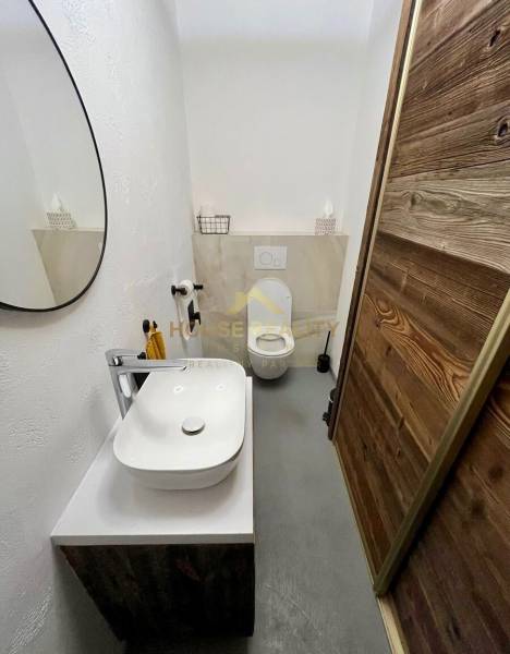Koupelna v 3-pokojovém bytě se zrcadlem, umyvadlem a moderní dekorací.