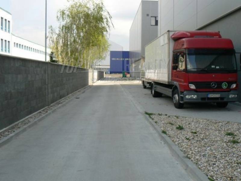 Na ulici Stará Vajnorská, červený kamion u skladových hal.