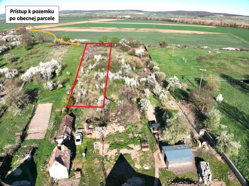 Zahradní parcela v Gemeru s přístupovou cestou, obklopená kvetoucími stromy a poli.