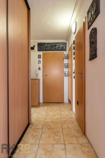 Chodba se skříní a dlažbou ve 4-pokojovém bytě.