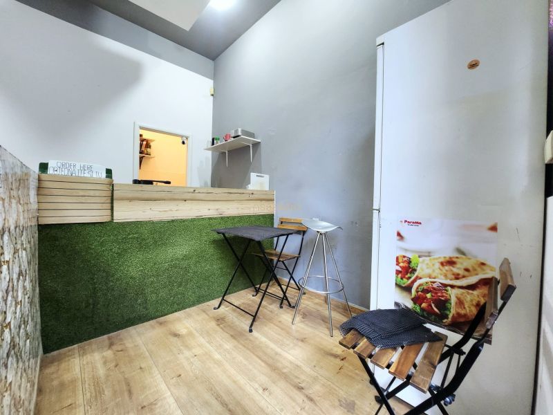 Gastro prostory s pultem, židlemi a podlahou s dřevěným dekorem.