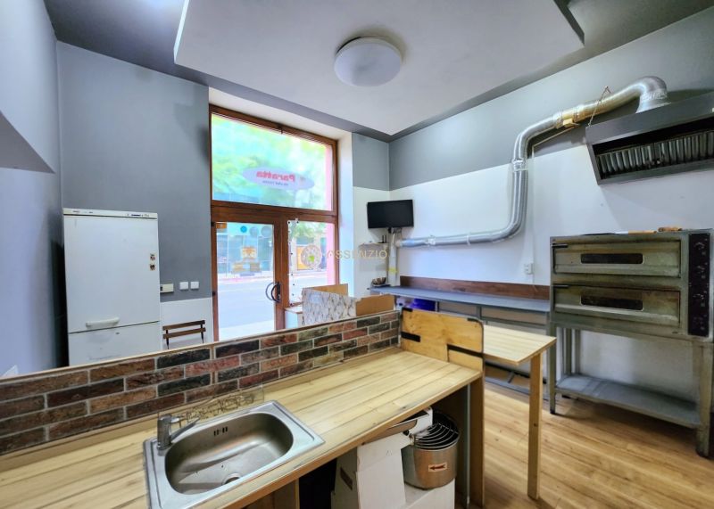 Interiér gastro prostorů s kuchyňským vybavením a podlahou s dřevěným dekorem.