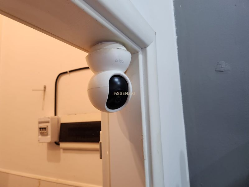 Bezpečnostní kamera na zdi v gastro prostorech, pod ní elektroinstalace.