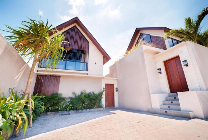 Vila na Bali se zahradou a palmami, moderní architektura, kamenný chodník.