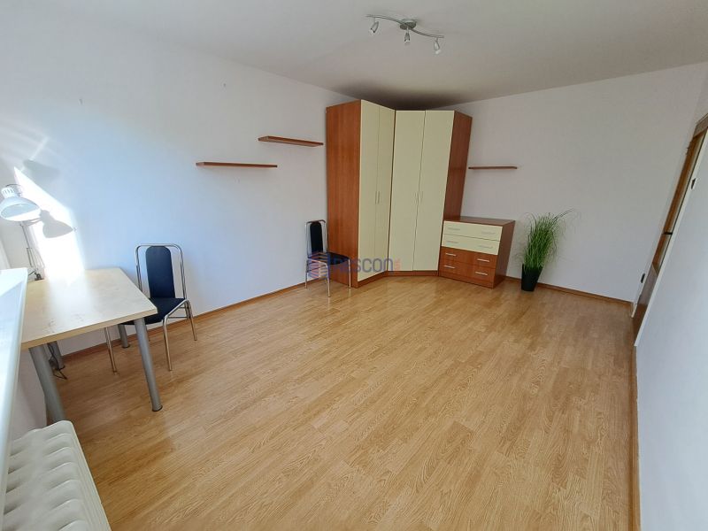 Pokoj v 2-pokojovém bytě s nábytkem a podlahou s dřevěným dekorem.